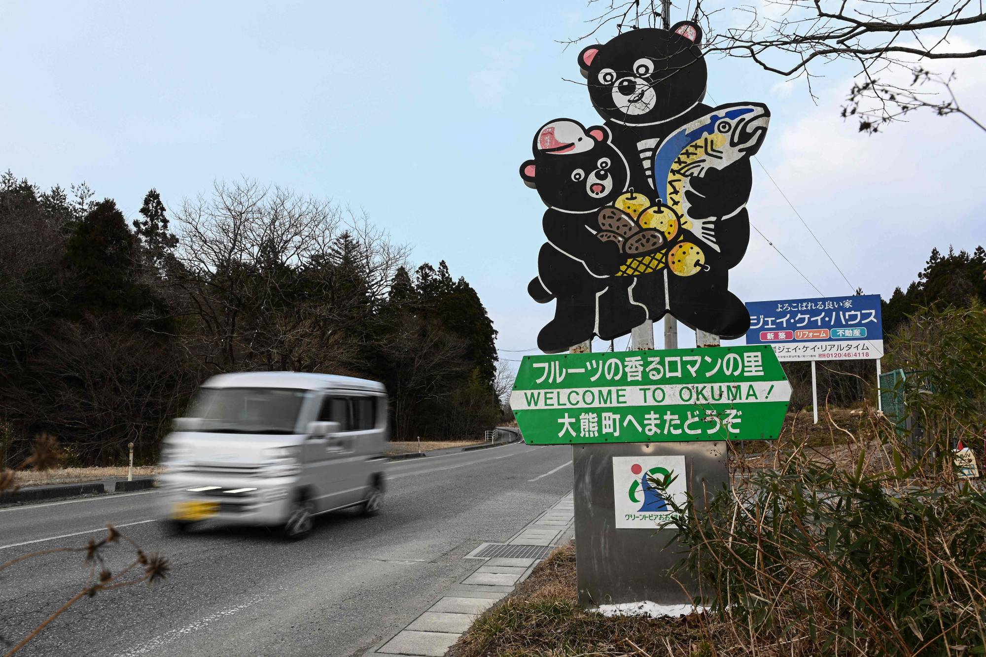 A car passes a sign welcoming visitors to the town of Okuma, Fukushima Prefecture, in February. Since evacuation orders for Okuma were lifted, nearly 400 residents lived in the town as of December, with a government target of 4,000 by 2027. | AFP-JIJI