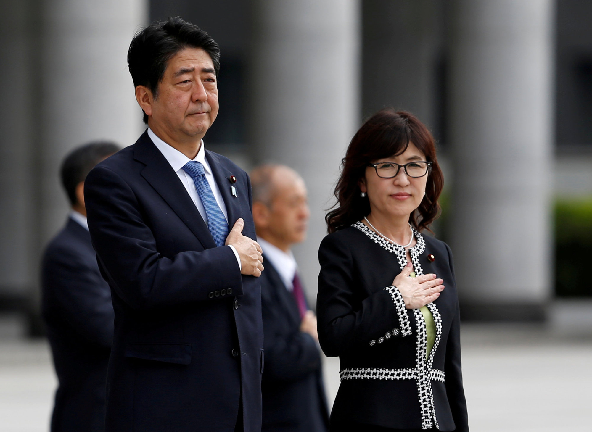 Prime Minister Shinzo Abe and then-Defense Minister Tomomi Inada review the honor guard before a meeting with senior members of the Self-Defense Forces' at the Defense Ministry in Tokyo last September. Inada announced her resignation on July 27. | REUTERS