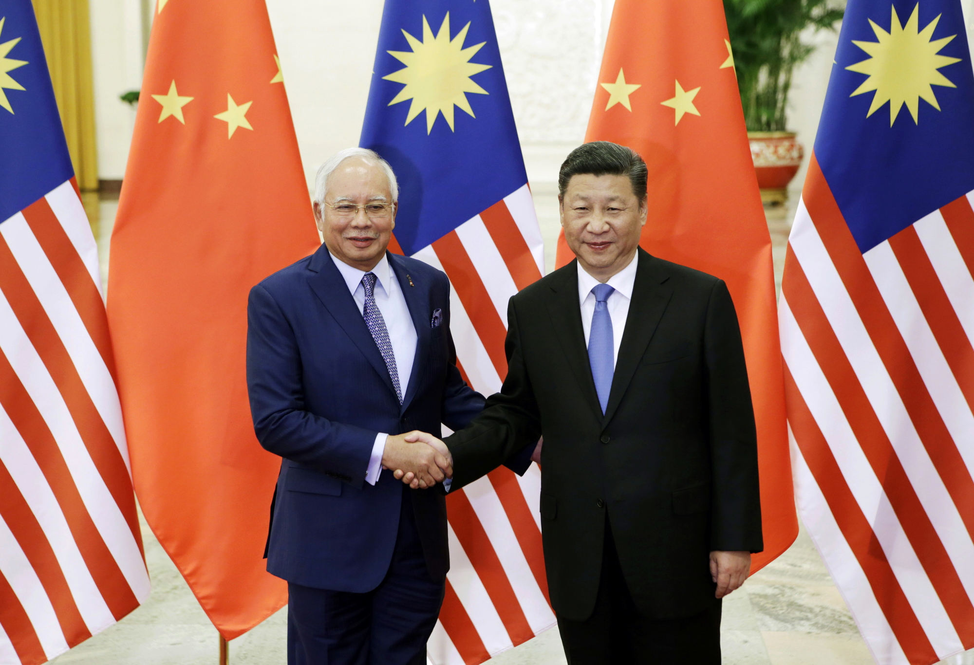 Malaysian Prime Minister Najib Razak (left) poses with Chinese President Xi Jinping before a meeting ahead of the Belt and Road Forum in Beijing on May 13. Under the Najib government, Malaysia is rapidly growing closer to China. | AP